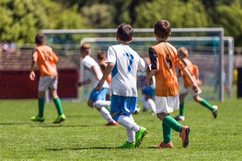 Boys Playing In A Soccer Match Football Youth Players Kicking Football