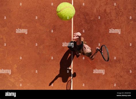 Top view of a professional female tennis player serves the tennis ball
