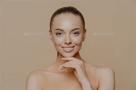 Cheerful Young Woman With Clean Glowing Skin Keeps Hand Under Chin