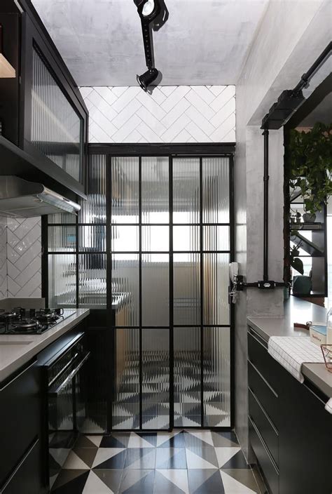 A Black And White Tiled Kitchen With Glass Doors