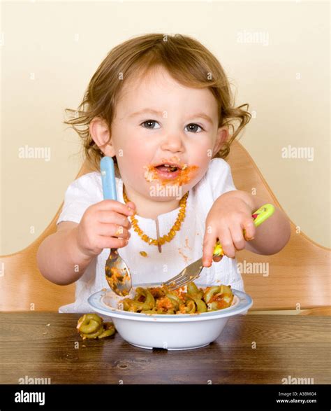 Baby Eating Pasta In High Chair Stock Photo Alamy