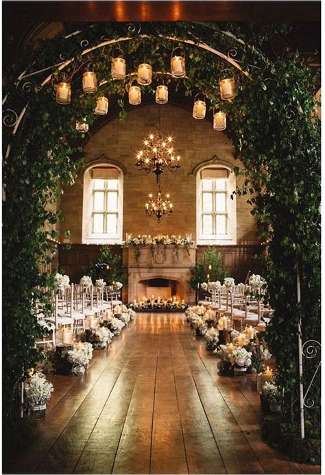 An Indoor Wedding Venue With Candles And Greenery