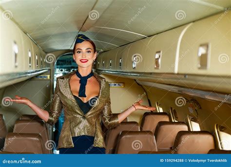 Beautiful Flight Attendant In An Airplane Cabin Smiling On A Board Of Commercial Airplane Air