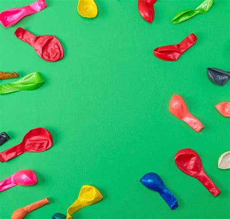 Colorful Deflated Balloons On A Green Background Premium Photo