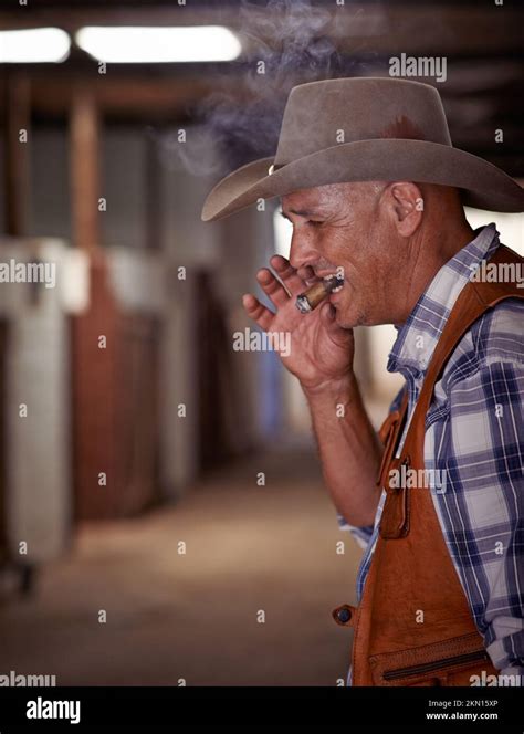 Tastes Like The West A Senior Cowboy Enjoying A Cigar On His Ranch