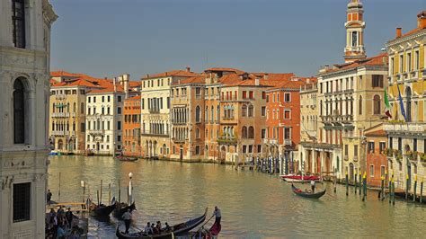People In Boat On River Between Buildings In Italy Venice