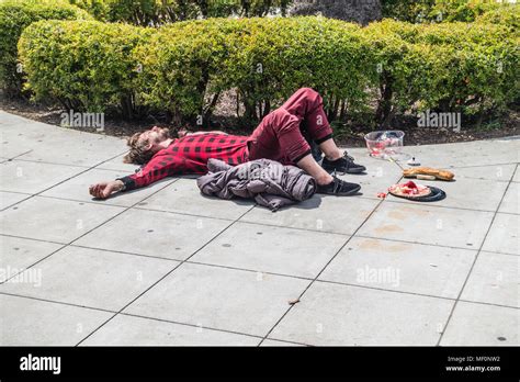 Homeless Person Passed Out On The Sidewalk Spread Eagle With His Arms