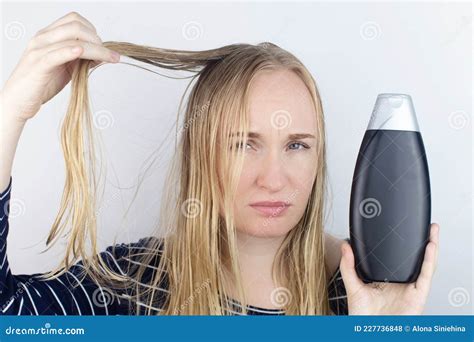 The Girl Looks In The Mirror At Her Oily Hair Then Takes A Shampoo To Treat Oily Hair