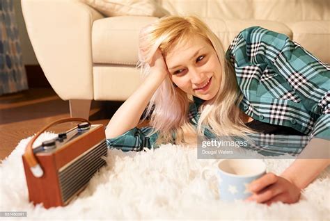 Woman Listening To Radio At Home With Hot Drink High Res Stock Photo