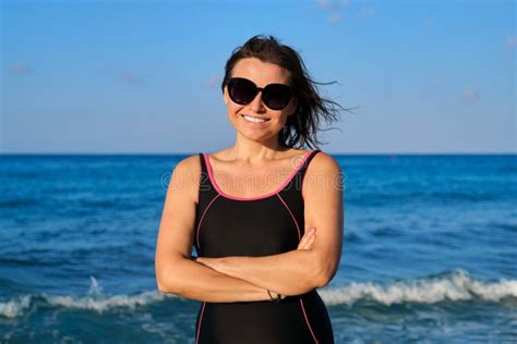 portrait of beautiful mature woman in sunglasses swimsuit smiling looking at camera stock image