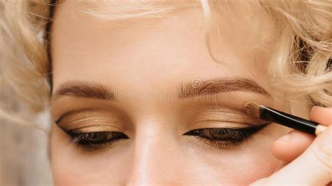 Shooting In A Beauty Salon A Master Makeup Artist Applies Blush Highlighter And A Sculptor To
