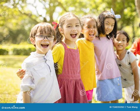 Multiethnic Group Of School Children Laughing And Embracing Stock Photo