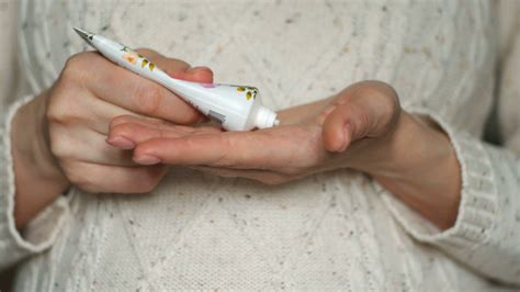 Close Up Shot Of A Woman`s Hands Spreading A Cream Over The Fingers