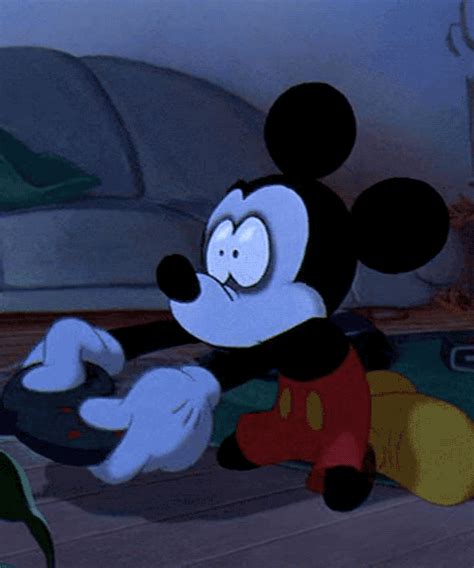 Mickey Mouse Sitting On The Floor Playing With A Video Game Controller