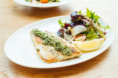 Pescado fresco a la plancha con unos ajitos por encima. Filete de lubina a la plancha con verdura | Foto Gratis