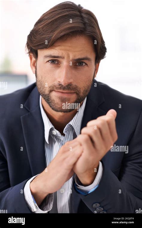 cool calm and collected portrait of a handsome businessman rubbing his hands together stock