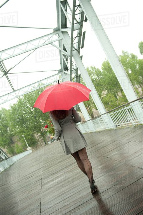 Caucasian Woman Walking In Rain With Red Umbrella Stock Photo Dissolve
