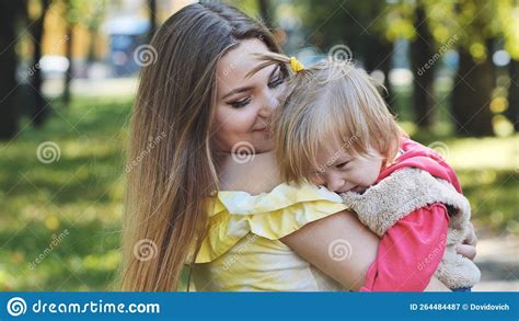 A Mother Hugs Her Young Daughter In The Park In The Summer Stock Image Image Of Cheerful
