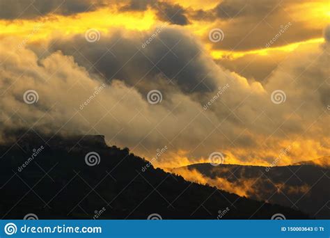 Heavy Clouds In Dusk Sunset With Mountains In Silhouette Stock Image