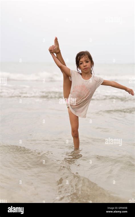 Kleines Mädchen auf einem Strand Wassergymnastik zu tun Stockfotografie Alamy