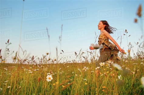 Girl Running Through Wildflower Meadow Stock Photo Dissolve