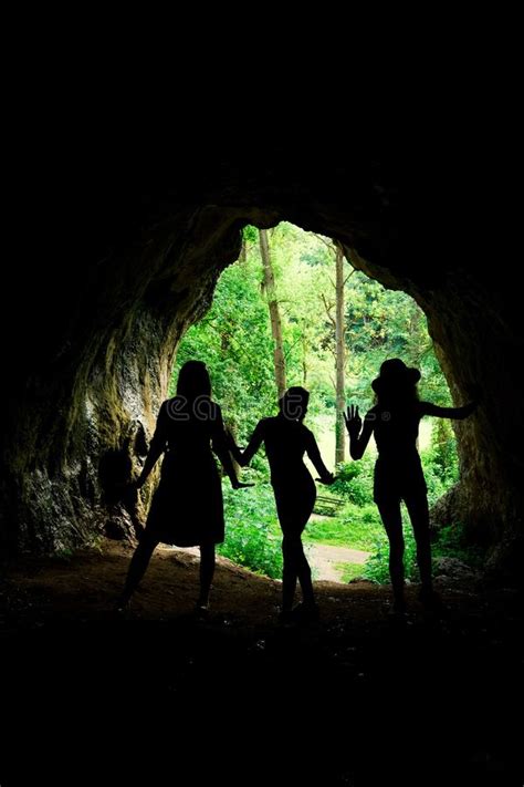 Dark Female Silhouettes At The Entrance To Natural Cave Stock Image