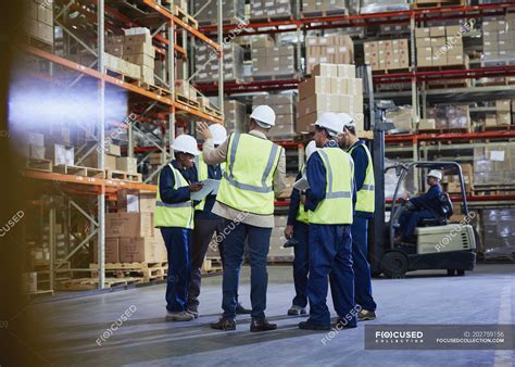 Manager And Workers Meeting In Distribution Warehouse — Togetherness