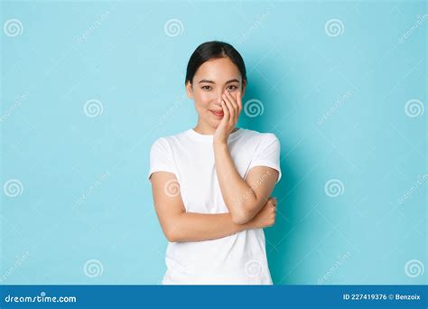 portrait of silly and cute asian girl in blue wig squinting and making funny faces showing