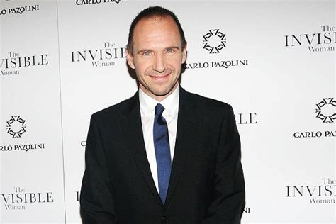 A Man In A Suit And Tie Posing For The Camera At An Invisible Woman Event