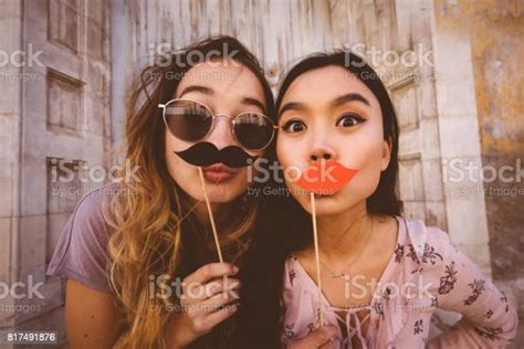 Women Making Faces With Mustaches And Lips On A Stick Stock Photo
