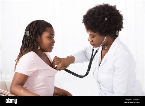 Female Doctor Examining A Patient With Stethoscope In Hospital Stock