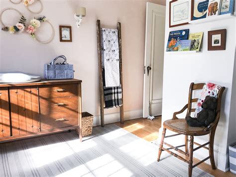 A Chair And Dresser In A Room With Pictures On The Wall