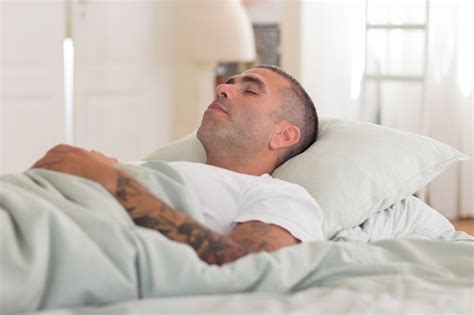 Carefree Caucasian Man Sleeping On Back In Bed Stock Photo Download