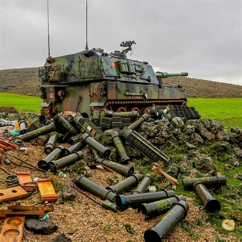 An Old Tank Sitting On Top Of A Field Next To Other Items And Equipment