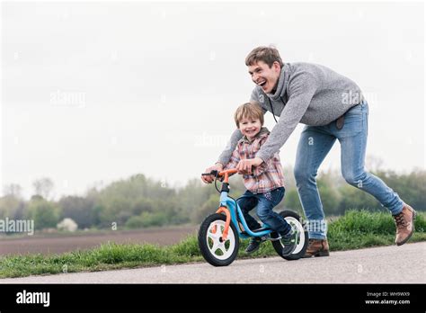 Padre Enseñando A Su Hijo A Andar En Bicicleta Fotografías E Imágenes