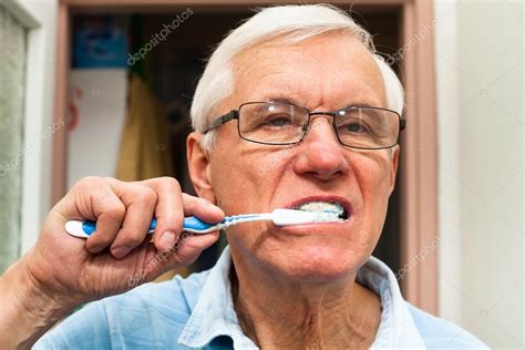 Senior Man Brushing His Teeth — Stock Photo © Janmika 19419497