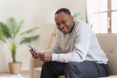 Young African American Man Using Mobile Cell Phone Hold Credit Bank