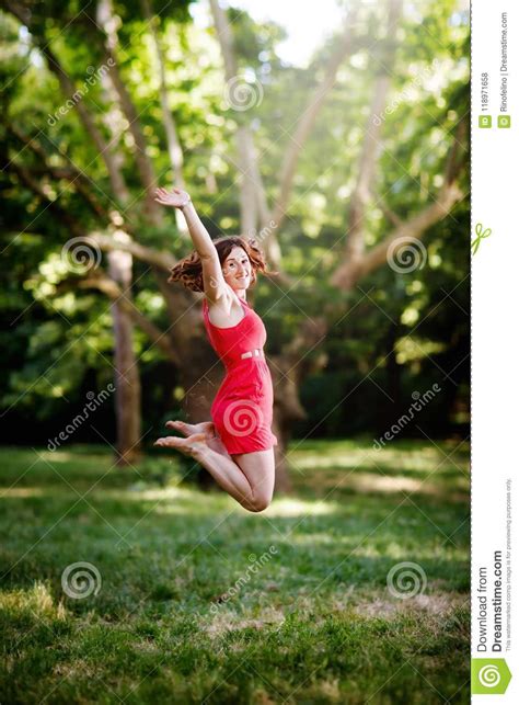 Happy Young Woman Jumping For Joy In The Woods Stock