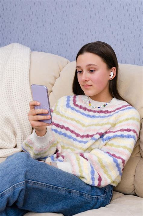 Portrait Of A Young Teenage Girl Using Smartphone With Earphones Social