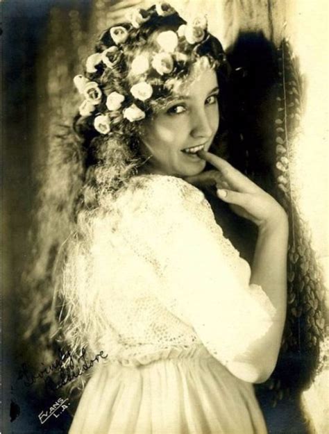 An Old Photo Of A Woman With Flowers In Her Hair Wearing A Dress And