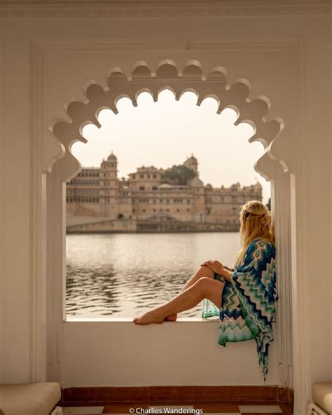 A Woman Sitting On A Ledge Looking Out Over The Water
