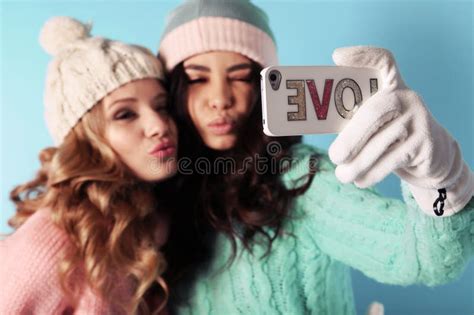 Two Beautiful Girls In Warm Cozy Clothes Having Fun In Studio Stock