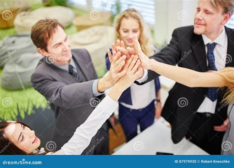 Business People Give Each Other A High Five In The Office Stock Photo