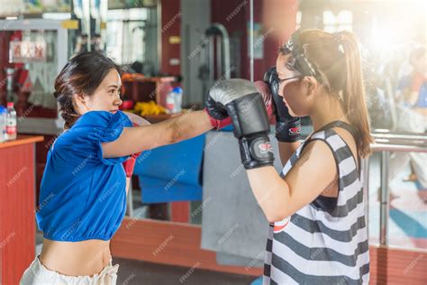 Premium Photo Two Female Boxing Friends Exercising In Gymnasium