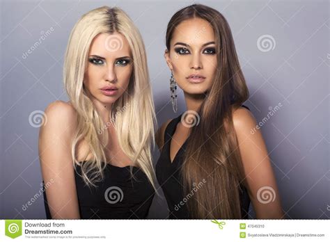 Blond Et Brunette Deux Filles Sexy Avec Les Cheveux Luxueux Posant Dans