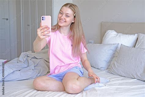 Cute Girl 15 18 Years Old Sitting On The Bed Makes A Selfie Stock