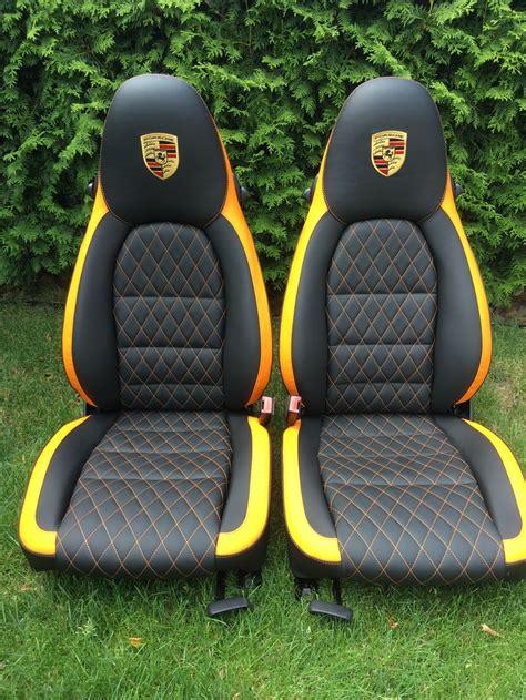 Two Black And Yellow Racing Seats Sitting In The Grass Next To Each