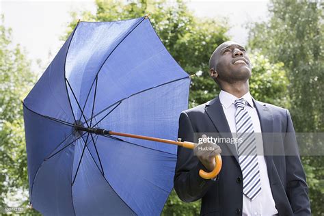 Businessman Holding Umbrella Realising The Rain Has Stopped High Res