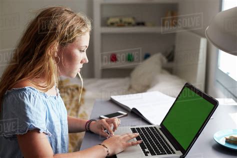 Teenage Girl Using Laptop At A Desk In Her Bedroom Close Up Stock