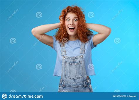 excited amused joyful redhead curly girl having amazing perfect news touch hair astonished stare